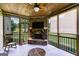 Cozy screened porch featuring a stone fireplace, wooden ceiling and beams, and an outdoor ceiling fan at 127 Grayson Myers Dr, Villa Rica, GA 30180