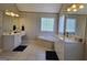 Bright bathroom with dual vanities, a soaking tub, and tiled floors at 176 Fairoaks Cir, Stockbridge, GA 30281