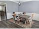 Dining room with modern light fixture, four chairs, a dining table, and wainscoting details at 176 Fairoaks Cir, Stockbridge, GA 30281