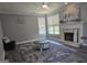 Cozy living room with fireplace, ceiling fan, wood floors, and a decorative rug at 176 Fairoaks Cir, Stockbridge, GA 30281