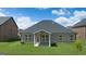 Backyard featuring stone patio, brick exterior, and green lawn at 1812 Quaker St, Hampton, GA 30228