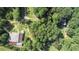 Aerial shot showcasing the property with lush greenery, outbuildings, and ample space at 2371 Leguin Mill Rd, Locust Grove, GA 30248