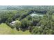Beautiful aerial view showcasing the property's serene lake, barn, and lush surrounding landscape at 2371 Leguin Mill Rd, Locust Grove, GA 30248