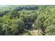 Aerial view of a charming home nestled among mature trees with a view of the nearby lake at 2371 Leguin Mill Rd, Locust Grove, GA 30248