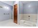 Bathroom featuring a shower, bathtub, and wooden door at 2371 Leguin Mill Rd, Locust Grove, GA 30248