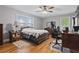 Cozy bedroom with hardwood floors, ceiling fan, and natural light from two windows at 2371 Leguin Mill Rd, Locust Grove, GA 30248