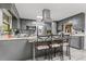 Modern kitchen with gray cabinets, stainless steel appliances, and center island with chairs at 2371 Leguin Mill Rd, Locust Grove, GA 30248