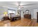 A spacious main bedroom featuring wood floors, ceiling fan, and ensuite bathroom at 2371 Leguin Mill Rd, Locust Grove, GA 30248