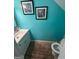 Bright blue powder room featuring a white vanity, toilet, and zebra artwork at 6444 Charter Way, Lithonia, GA 30058