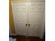 White bi-fold doors of a closet with wood floors at 6444 Charter Way, Lithonia, GA 30058