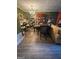 Open-concept living space with hardwood floors and bar area with adjacent dining at 6444 Charter Way, Lithonia, GA 30058