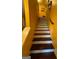 Inviting staircase featuring hardwood steps and white risers against yellow walls at 6444 Charter Way, Lithonia, GA 30058