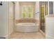 A bathtub sits between a pair of windows and a glass enclosed shower at 115 Edgewood Pkwy, Fayetteville, GA 30215