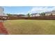 Large backyard featuring a well-maintained lawn, a wooden fence, and a newly planted tree for added privacy at 5396 Pennington Ct, South Fulton, GA 30349
