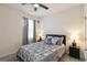 Comfortable bedroom features soft gray bedding, bedside lamps, a ceiling fan, and a window with natural light at 5396 Pennington Ct, South Fulton, GA 30349