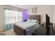 Cozy bedroom featuring a bed with soft blue bedding, accent lighting, and sheer curtains for natural light at 5396 Pennington Ct, South Fulton, GA 30349