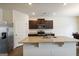 Clean kitchen featuring stainless steel appliances, an island with a sink, and dark wood cabinets at 5396 Pennington Ct, South Fulton, GA 30349