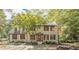 Charming two-story brick home with a well-manicured lawn and mature tree in a serene, wooded setting at 185 Chimney Springs, Tyrone, GA 30290