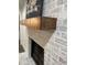 A fireplace with a wooden mantel against a white brick wall at 185 Chimney Springs, Tyrone, GA 30290