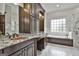 This elegant bathroom has a double vanity, granite countertops and hexagonal tile flooring at 210 Short Rd, Sharpsburg, GA 30277