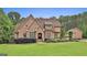 Beautiful brick home with a manicured lawn, mature trees, long driveway, and a guest house on a beautiful sunny day at 210 Short Rd, Sharpsburg, GA 30277