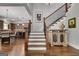 Inviting foyer with hardwood floors, staircase, and kitchen view featuring an open concept design at 10140 Grandview Sq, Duluth, GA 30097