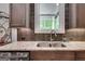 Close up view of the granite countertops, stainless steel sink, and tiled backsplash at 10140 Grandview Sq, Duluth, GA 30097