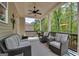 Relaxing covered patio featuring comfortable seating, ceiling fan, and view to trees and backyard at 10140 Grandview Sq, Duluth, GA 30097