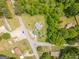 An aerial view showcasing a home with outbuildings situated on a fenced lot surrounded by trees and landscaping at 40 N Villa Rd, Villa Rica, GA 30180
