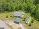 Aerial view of a charming home with green roof accents, surrounded by a well-manicured lawn and mature trees at 40 N Villa Rd, Villa Rica, GA 30180
