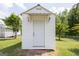 An exterior shot of an outbuilding/shed with a white door on a well manicured lot with a house nearby at 40 N Villa Rd, Villa Rica, GA 30180