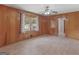 Cozy bedroom with wood paneled walls, ceiling fan, window, and a hardwood floor at 3 Ridge Dr, Hampton, GA 30228