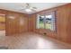 Spacious bedroom with wood paneled walls, ceiling fan, window, and a hardwood floor at 3 Ridge Dr, Hampton, GA 30228
