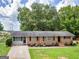 Inviting single-story home featuring a brick facade, lush lawn, and mature trees at 3 Ridge Dr, Hampton, GA 30228