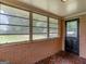 Well-lit sunroom with brick accents and large windows overlooking a green yard at 3 Ridge Dr, Hampton, GA 30228