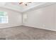 Carpeted primary bedroom with tray ceiling and two windows at 3130 Lower Creek Dr, Douglasville, GA 30135