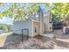 Home exterior with grey siding, brick chimney, concrete patio, tiered retaining wall, and fenced backyard at 3130 Lower Creek Dr, Douglasville, GA 30135