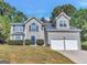 Charming home with a blue door, a two-car garage, and a well-manicured lawn at 3130 Lower Creek Dr, Douglasville, GA 30135