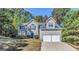 Charming two-story home featuring a two-car garage, complemented by a well-maintained lawn and mature trees at 3130 Lower Creek Dr, Douglasville, GA 30135