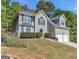 Traditional home featuring a two-car garage, manicured lawn, and mature trees at 3130 Lower Creek Dr, Douglasville, GA 30135