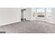 Open-concept living room with neutral carpet, natural light, and light walls at 3130 Lower Creek Dr, Douglasville, GA 30135