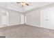 Spacious main bedroom featuring a tray ceiling, ceiling fan, and large walk-in closet for ample storage at 3130 Lower Creek Dr, Douglasville, GA 30135