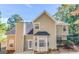 Beige two-story home featuring a backyard concrete patio area and a bay window under a clear blue sky at 3130 Lower Creek Dr, Douglasville, GA 30135