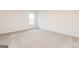 Bright bedroom featuring neutral carpet, fresh white walls, and a window at 244 Oliver Dr, Locust Grove, GA 30248