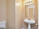A half bath features a pedestal sink, mirror, and lighting at 145 Tara Way, Covington, GA 30016