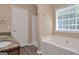 Neutral bathroom offering a soaker tub, granite counters, and updated fixtures at 145 Tara Way, Covington, GA 30016