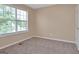 Sun-drenched bedroom offers carpet and natural light through the window at 145 Tara Way, Covington, GA 30016