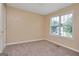 Bedroom with neutral walls and plush carpeting; brightened by a window and natural light at 145 Tara Way, Covington, GA 30016