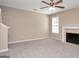 Carpeted living room with fireplace, mantle, and ceiling fan at 145 Tara Way, Covington, GA 30016