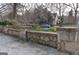 House with stone wall, landscaping, and a blue car parked in front of the house at 32 Highland Ne Dr, Atlanta, GA 30305